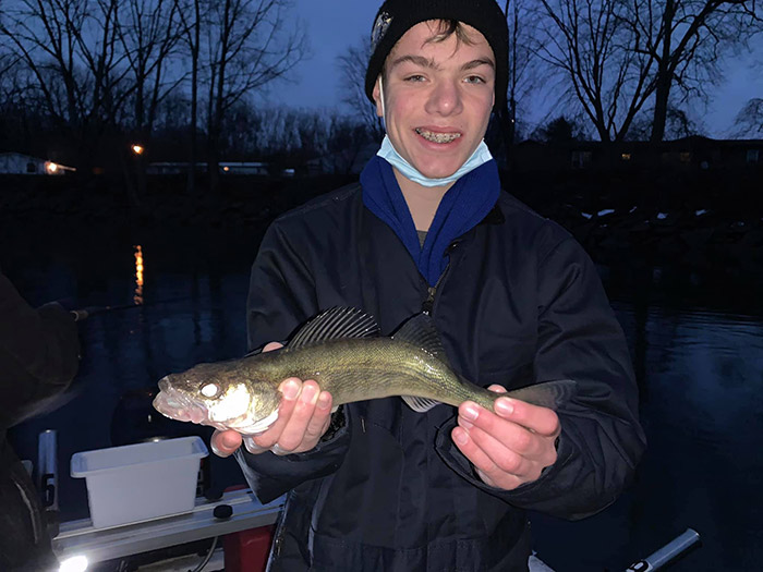 kid holding up a walleye on a fishing charter