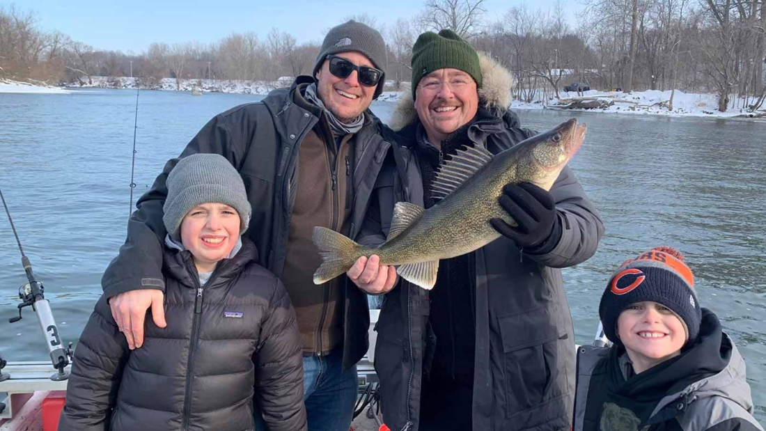 people holding a walleye on a fishing charter